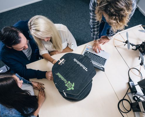 Studierende mit Roboter und Drohne