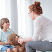 Kinderpsychologin mit Jungem und Teddybär