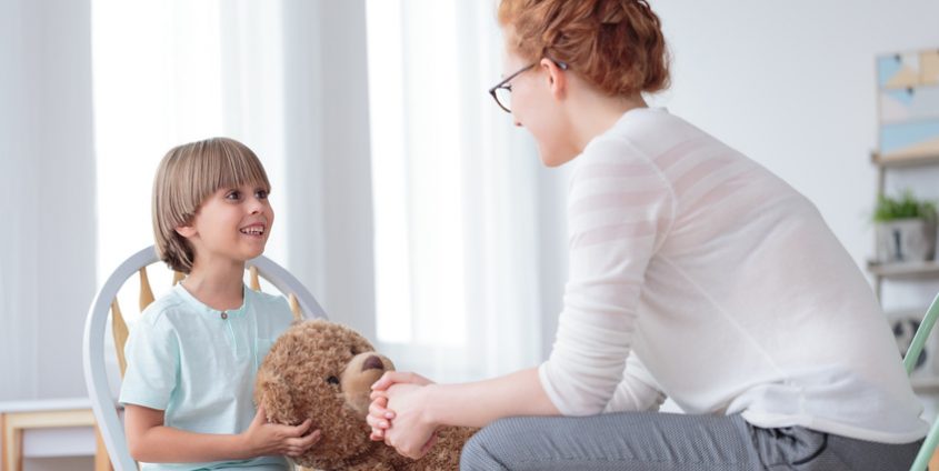 Kinderpsychologin mit Jungem und Teddybär