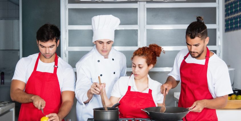 Chefkoch mit Team in der Küche