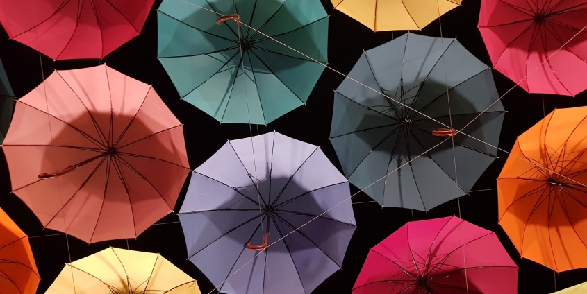 Regenschirme in verschiedenen Farben vor schwarzem Hintergrund