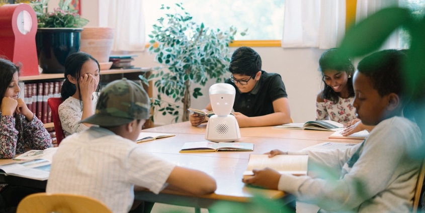 Avatar in Schulklasse, Kinder sitzen um den Mini-Roboter rundherum