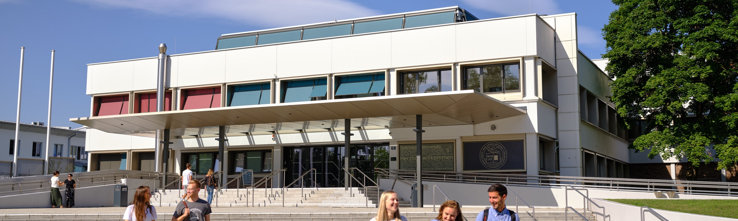 Studierende vor dem Haupteingang der Universität Klagenfurt