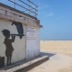 Das Bild von Streetart-Künstler Banksy am Strand von Calais zeigt ein Mädchen mit einem Koffer und einem Fernrohr, auf dem ein Geier sitzt. Von Calais aus kann man die englische Stadt Dover am anderen Ende des Ärmelkanals erblicken.