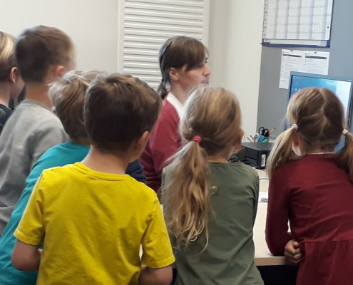 Die Kinder schauen zu, wie Frau Universitätsassistentin Klein am Computer arbeitet.