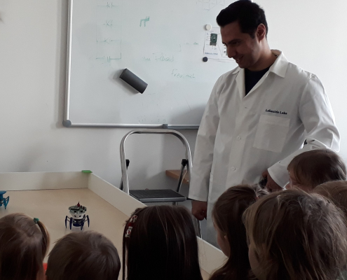 Forschungsassistent Youssefi zeigt den Kindern den Spiderino