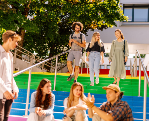 Studierende vor der Uni Klagenfurt, bunte Treppenstufen