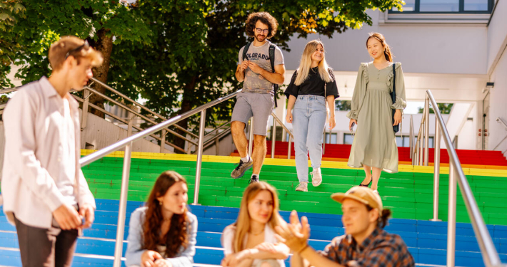 Studierende vor der Uni Klagenfurt, bunte Treppenstufen