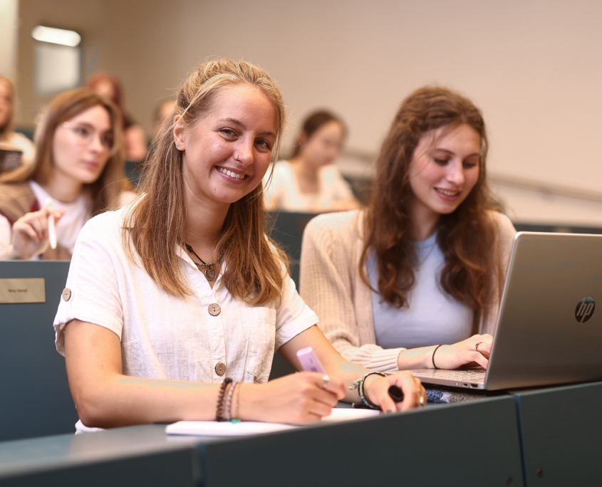 Studierende besuchen in einem Hörsaal der Universität Klagenfurt eine Lehrveranstaltung. | Foto: aau/Daniel Waschnig Mehrere Studierende sitzen in den gestuften blaufarbigen Sitzreihen eines Hörsaals der Universität Klagenfurt.