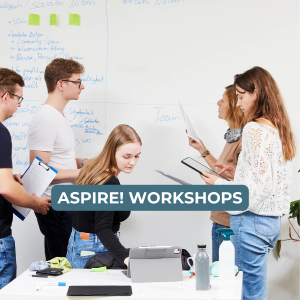 aspire Workshop Menschen die gemeinsam vor einer weißen beschreibbaren Wand arbeiten.